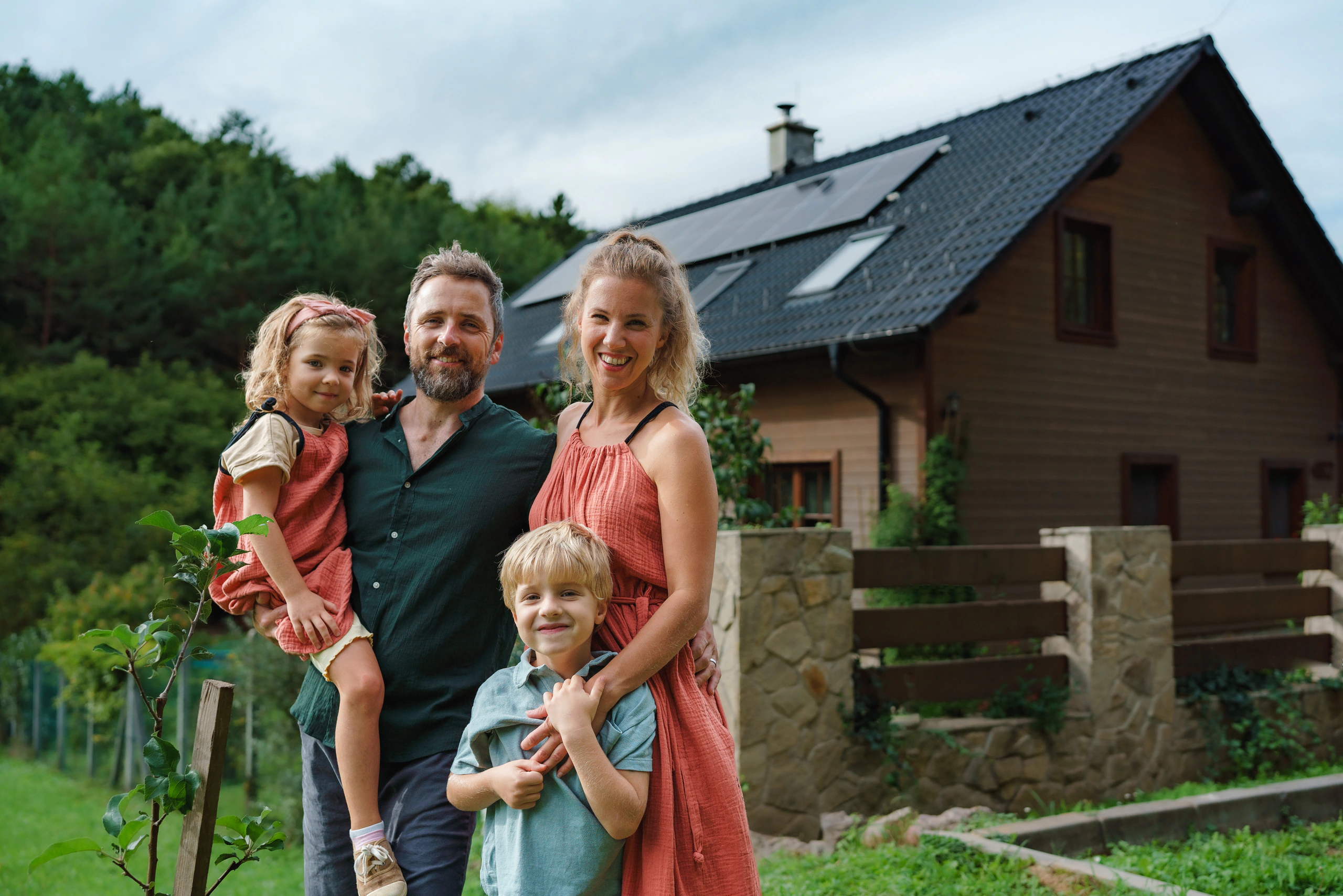 Familie mit Solaranlage auf Haus im Hintergrund