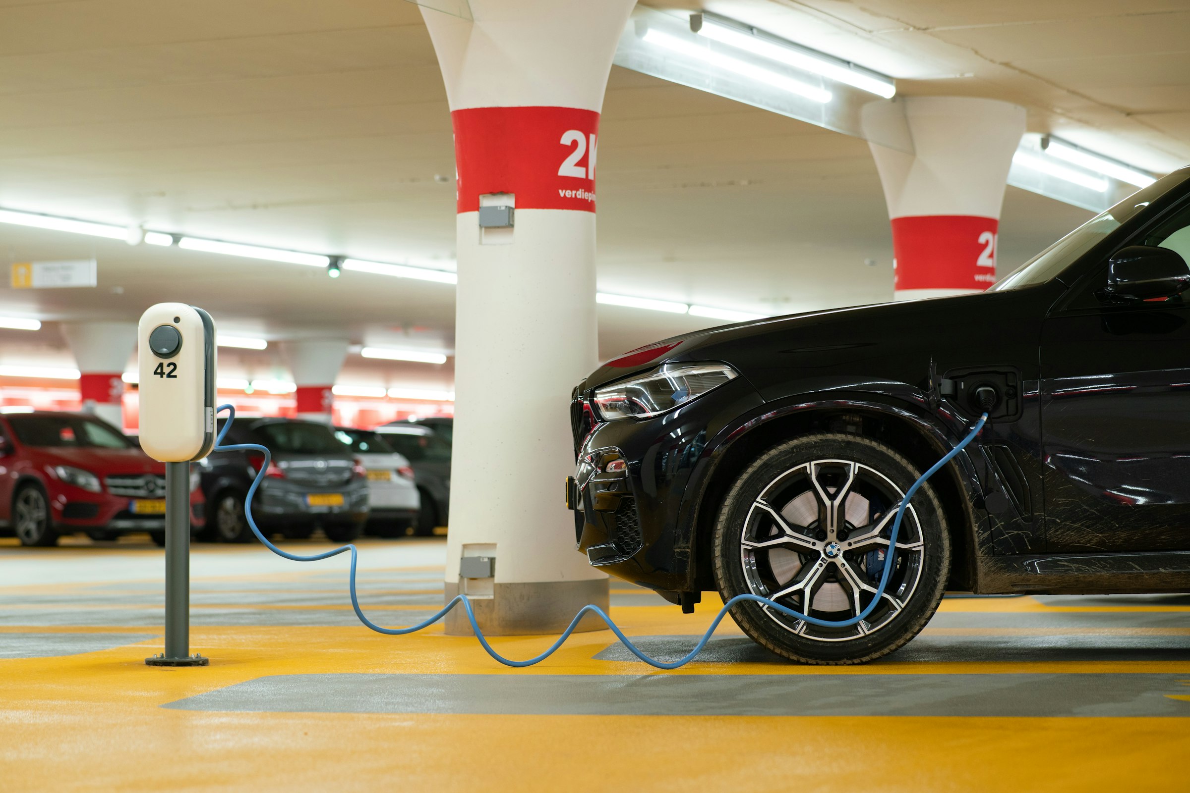 Elektroauto lädt an einem Ladepunkt in einer Tiefgarage, Ladeinfrastruktur für Wohnanlagen und Unternehmen