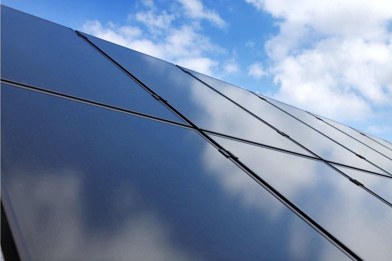 Photovoltaikanlage mit Solarmodulen vor blauem Himmel zur Stromerzeugung aus Sonnenenergie