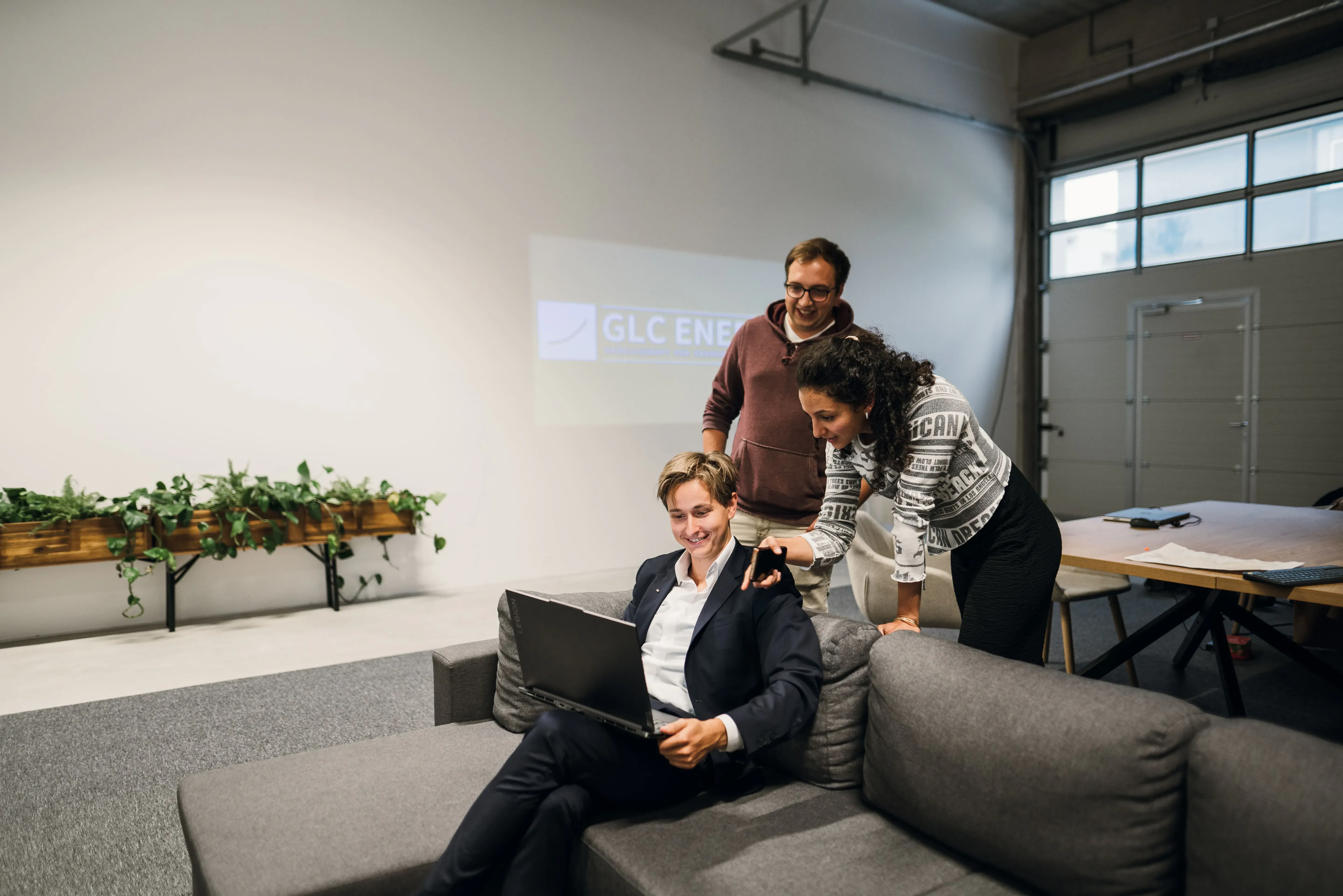 Drei Personen besprechen gemeinsam Ideen am Laptop im modernen Büro